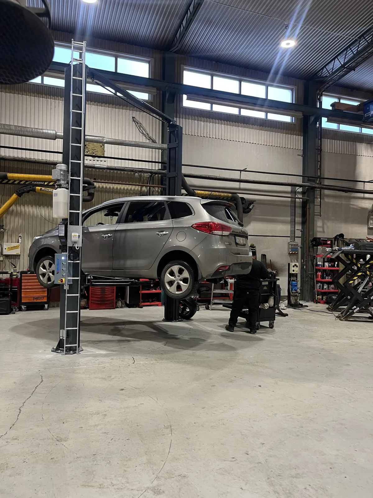 Silverfärgad bil upplyft i TS-Motors verkstad